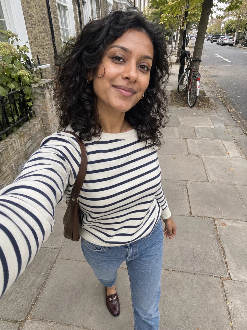 A casual outdoor selfie, wearing a striped top and jeans